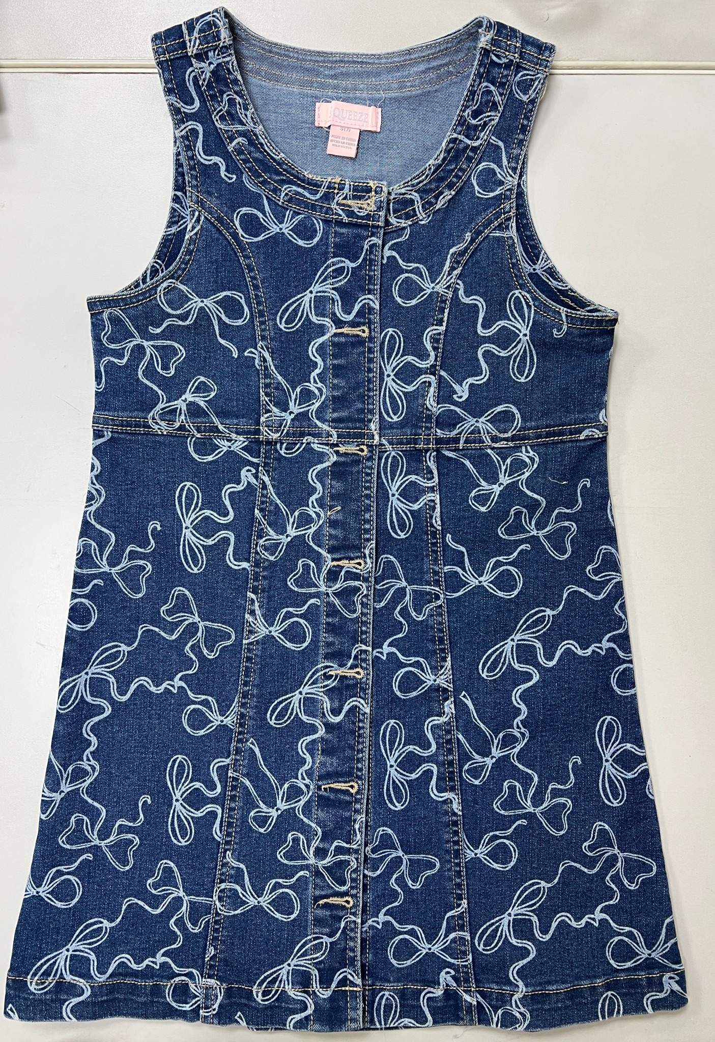 Sleeveless denim dress sample with a bow pattern